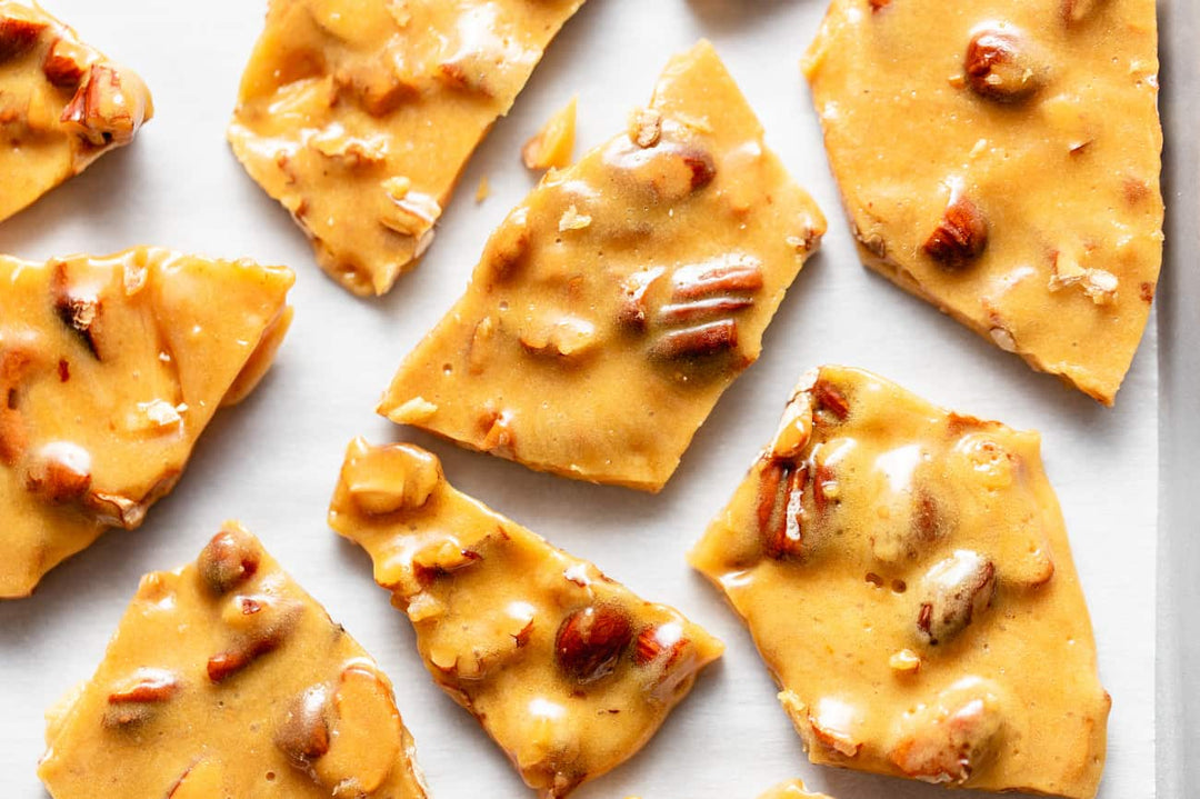 Pieces of peanut brittle arranged on a white surface
