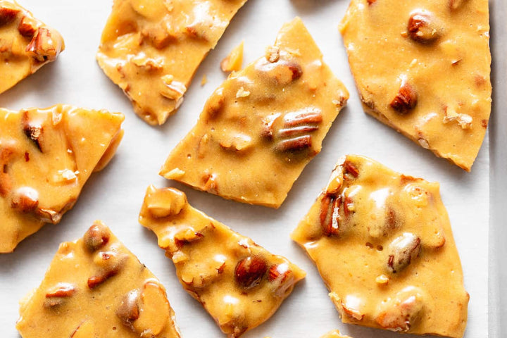 Pieces of peanut brittle arranged on a white surface