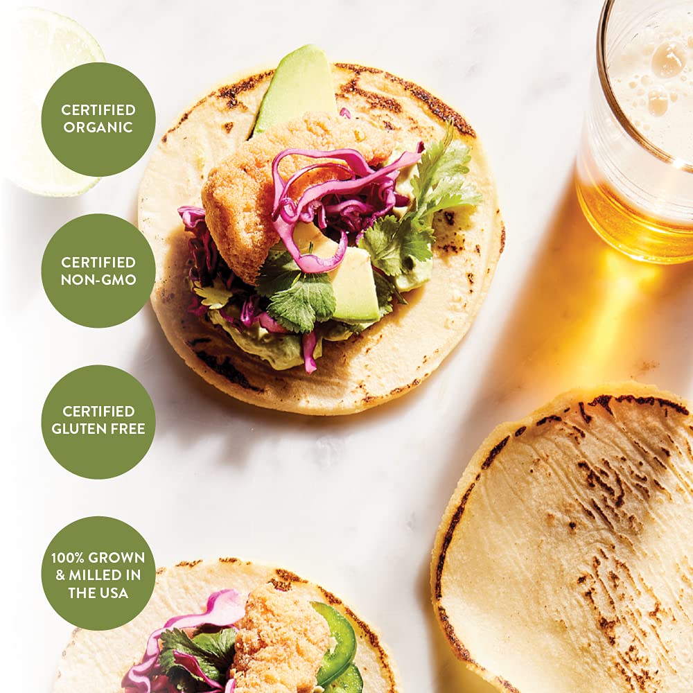 Tortilla with toppings and a glass of beer on a white surface, with certification labels around.