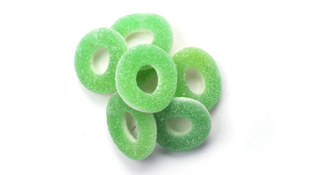 Green gummy apple rings on a white background