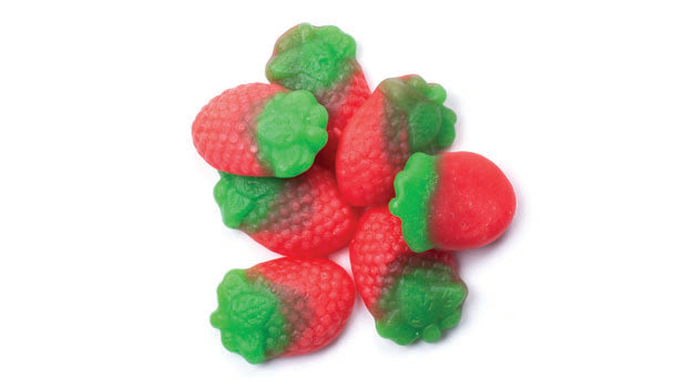 Pink and green strawberry-shaped gummy candies on a white background