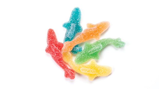 Colorful gummy sharks, light sour on a white background
