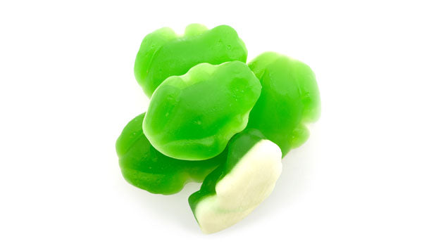 Green frog-shaped gummy candies on a white background