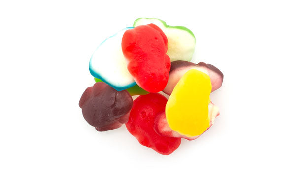 Assorted mini gummy frogs candy on a white background