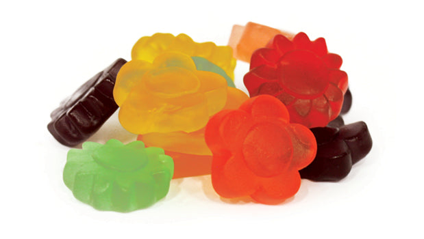 Colorful jelly candy shaped like flowers on a white background