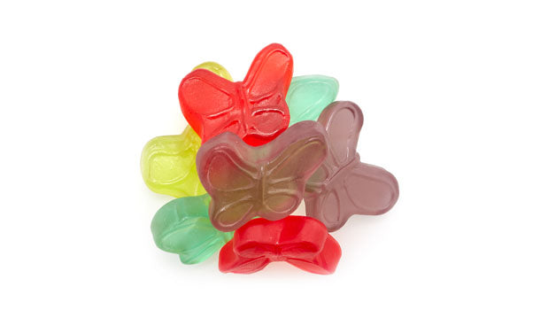 Colorful butterfly-shaped candies on a white background