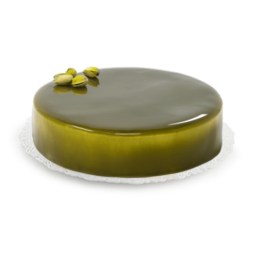 Gelato Cake coated with pistachio mirror glaze and garnished with 4 pistachio nuts on a white background