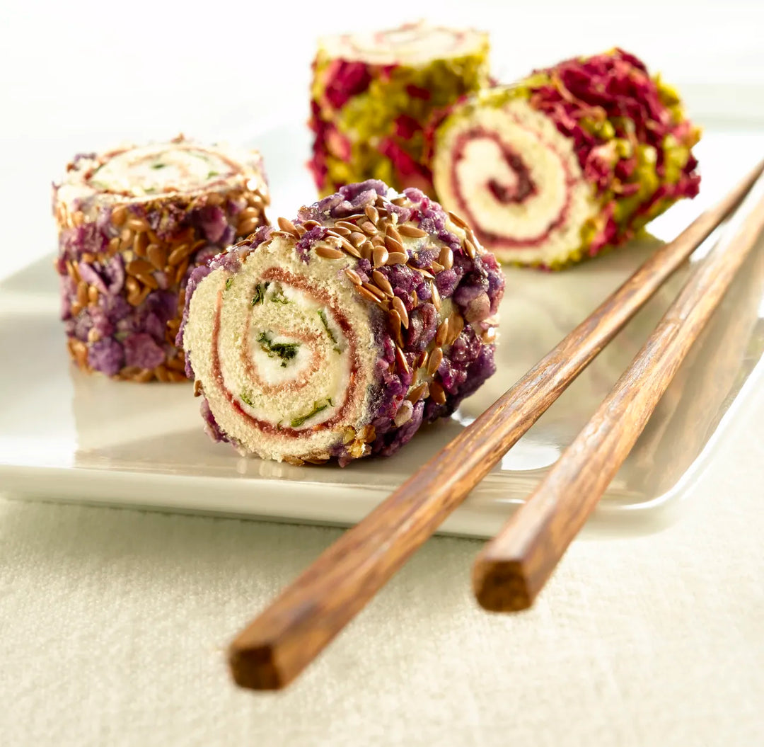 Three sliced roll cakes with different fillings on a plate with chopsticks made with Purato Canada
