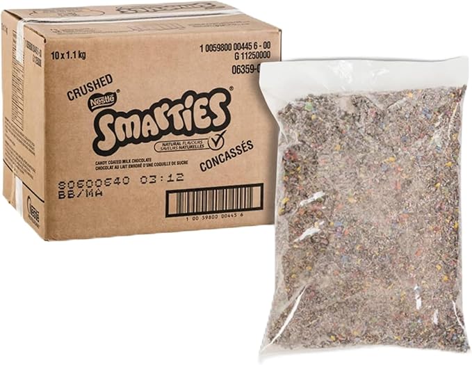 Box and bag of crushed Smarties candy on a white background