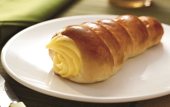Roll of crescent dough with cheese on a white plate Puratos Canada