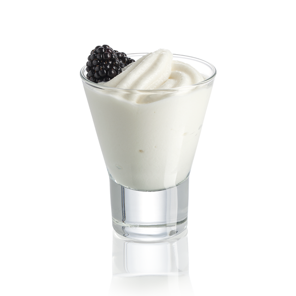 Glass cup filled with frozen flavoured cream-ice garnished with a blackberry on a white background
