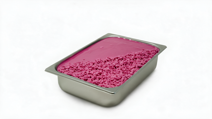 A rectangular stainless steel food pan filled with bright pink dessert or frosting, with the front portion sprinkled with coarse pink crumbs, photographed on a white background.