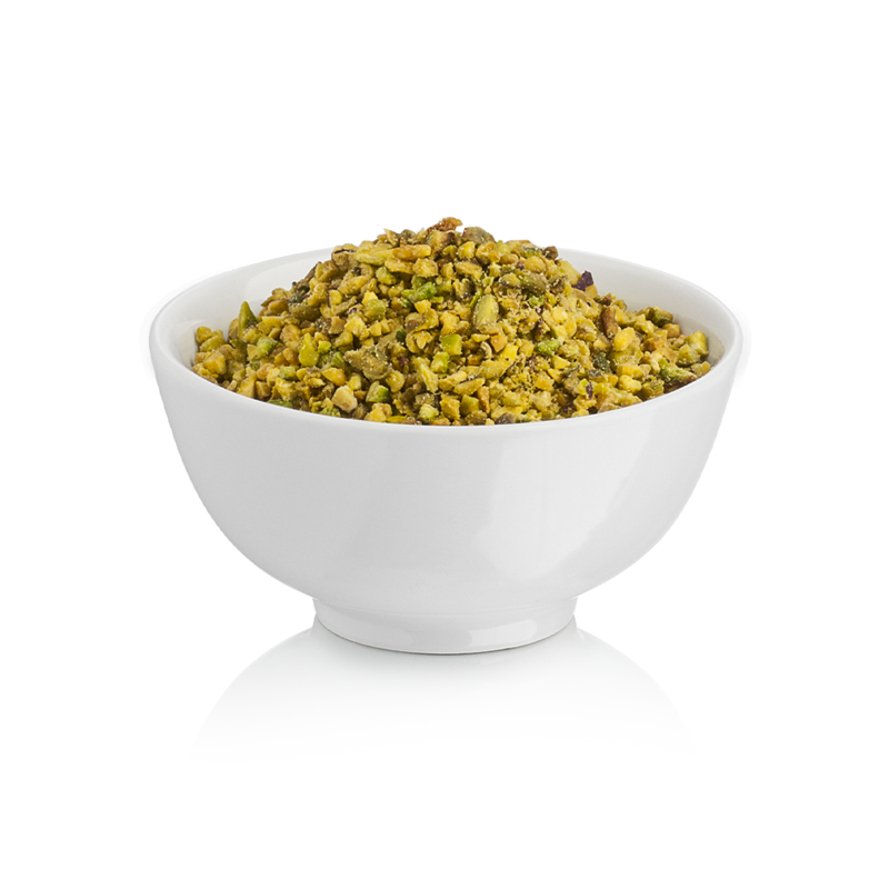 White bowl filled with Rubicone chopped green pistachio pieces on a white background