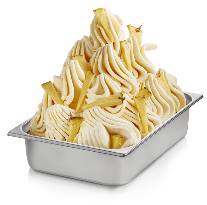 Pineapple gelato in a wide stainless steel pan with pineapple pieces made with Rubicone Pineapple Ready Base