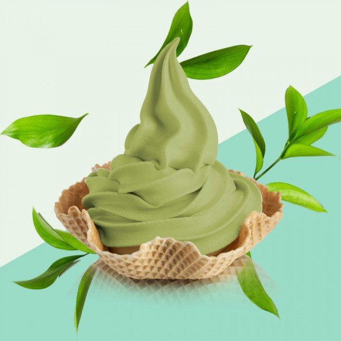Green matcha soft serve ice cream in a waffle cup with leaves on a light green and blue gradient background