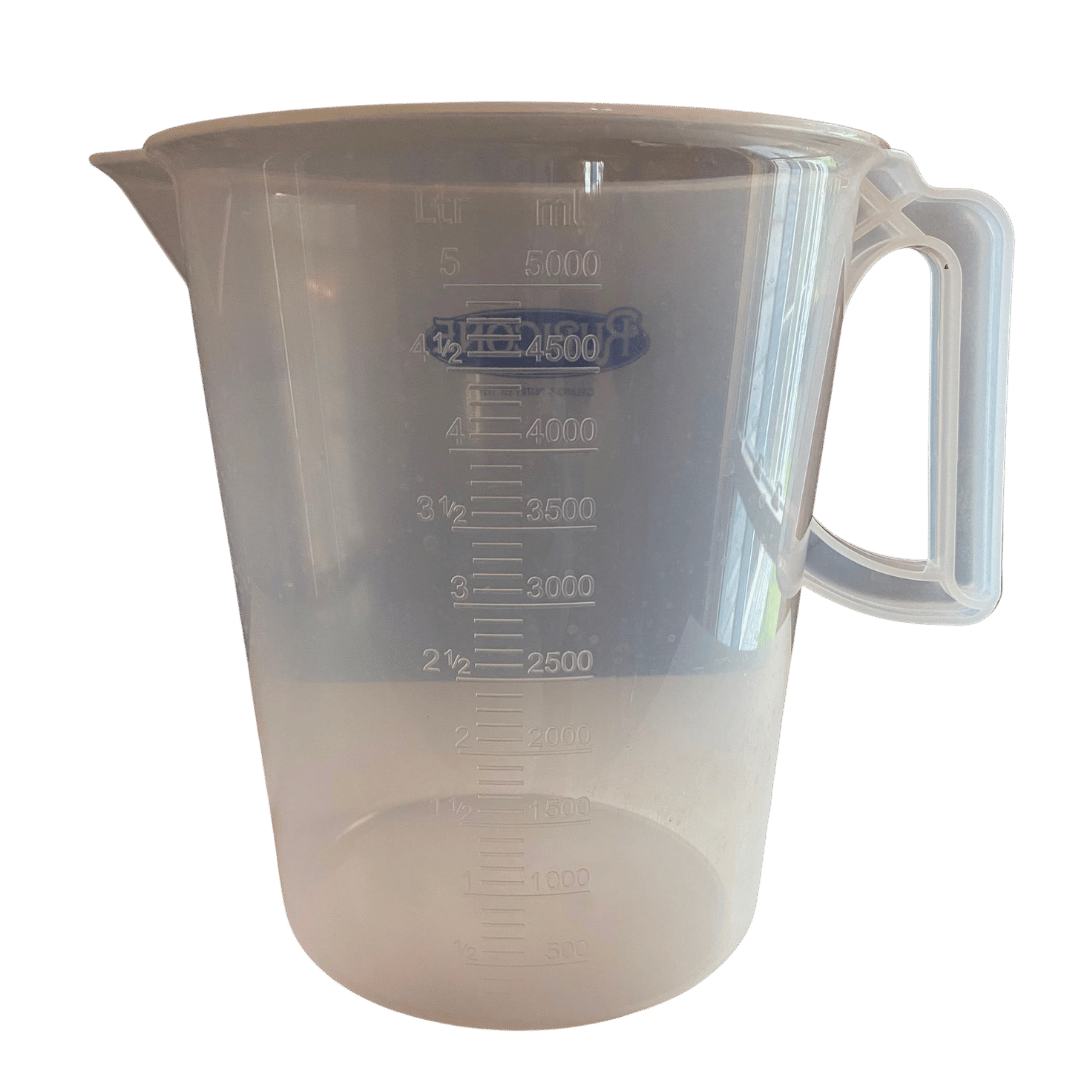 Clear plastic measuring cup with measurement markings on a white background